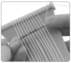 Beads being threaded on loom